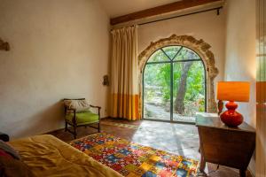 a bedroom with a bed and a window and a chair at Maison de charme avec jacuzzi in Lorgues