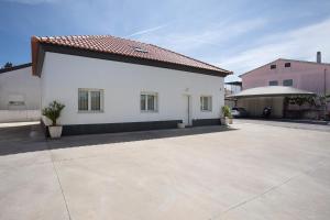 a white house with a driveway in a parking lot at Monte Dos Pastorinhos in Fátima