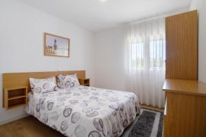a white bedroom with a bed and a window at Monte Dos Pastorinhos in Fátima