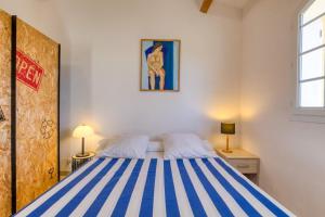 a bedroom with a bed with blue and white stripes at La Madrague St Vincent Apt A in Le Grau-dʼAgde +21 photos