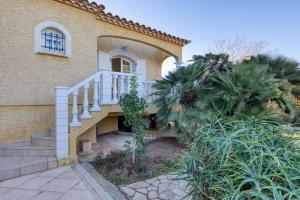 a house with stairs and a palm tree in front of it at La Madrague St Vincent Apt A in Le Grau-dʼAgde
