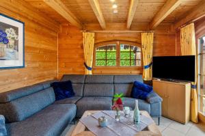 a living room with a couch and a flat screen tv at Das Alpenhaus an der Ems in Walchum