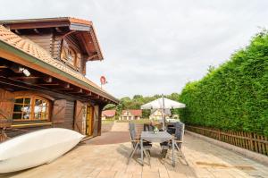 a patio with a table and an umbrella and a boat at Das Alpenhaus an der Ems in Walchum