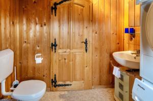 a wooden bathroom with a toilet and a sink at Das Alpenhaus an der Ems in Walchum +15 photos