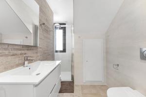 a white bathroom with a sink and a toilet at Belle in Orihuela Costa +18 photos