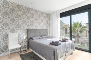 a bedroom with a bed and a chair and a window at Belle in Orihuela Costa