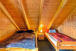 a bedroom with a bed in a wooden attic at Das Alpenhaus an der Ems in Walchum
