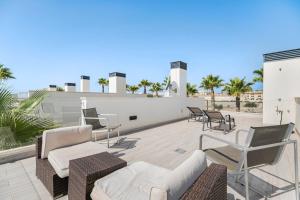 a patio with chairs and furniture on top of a building at Belle in Orihuela Costa