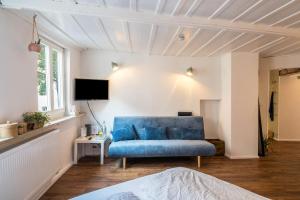 a living room with a blue couch and a tv at Fewo Sankt Johann ll in Konstanz
