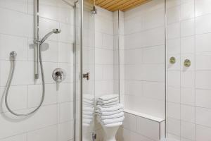 a white bathroom with a shower and towels at Haus Steinhäusle - 2 fewos in Vöhrenbach