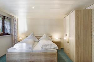 a bedroom with a bed with white sheets and pillows at Haus Steinhäusle - 2 fewos in Vöhrenbach