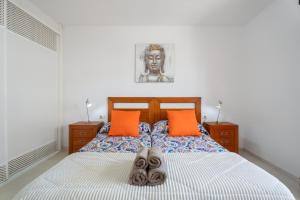 a bedroom with a bed with two orange pillows at Chasna Sunset in Adeje +14 photos