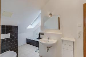 a bathroom with a sink and a toilet and a mirror at Ferienwohnung Familie Arnhofer in Waal +15 photos