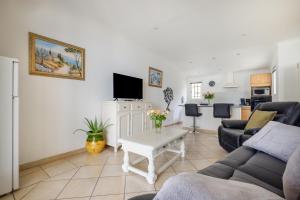 a living room with a couch and a table at Maison avec Piscine in Tourrettes