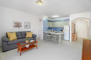 a living room with a couch and a kitchen at Chasna Sunset in Adeje