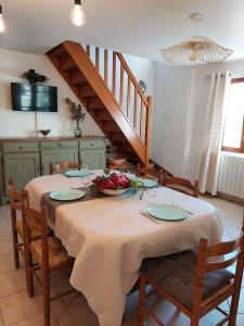 a dining room table with a bowl of flowers on it at Le Vieil Olivier in Sahune