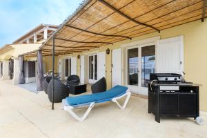 a patio with a grill and a blue bench at Maison avec Piscine in Tourrettes
