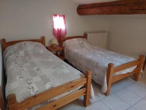two twin beds in a room with a window at Le Vieil Olivier in Sahune