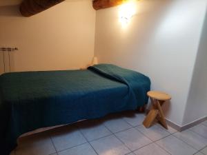 a small bedroom with a green bed and a stool at Le Vieil Olivier in Sahune +9 photos