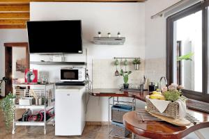 a kitchen with a table and a tv on a wall at Guenia I in Teguise