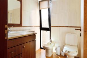 a bathroom with a toilet and a sink at Villa Aurélio in Campanário +16 photos