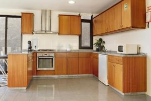 an empty kitchen with wooden cabinets and appliances at Villa Aurélio in Campanário