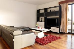 a living room with a couch and a tv at Villa Aurélio in Campanário