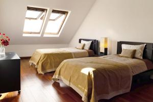 two beds in a room with two windows at Villa Aurélio in Campanário