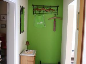 a room with green walls and hangers at Fewo-rosenberger-sauerland in Lennestadt +15 photos