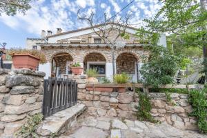 a stone house with a gate and a stone wall at Can Favo in Copóns