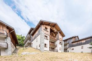 an exterior view of a large building with wooden at Appartement spa fleures d'Orelle in Orelle