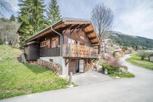 a wooden house with a balcony on the side of it at Chalet Nid Zut in Châtel
