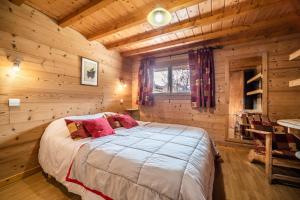 a bedroom with a bed in a log cabin at Chalet Nid Zut in Châtel