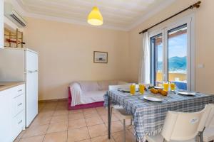 a kitchen and dining room with a table with chairs and a window at Villa Captain Fotis 4 in Póndi