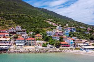 a group of houses on a hill next to the water at Villa Captain Fotis 4 in Póndi +17 photos