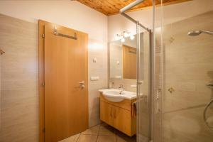 a bathroom with a sink and a glass shower at Speckign Apartment 3 in Cadipietra