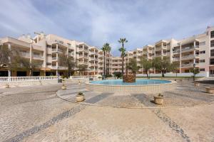 a courtyard with a fountain in front of some apartment buildings at Sol do Atlântico in Portimão
