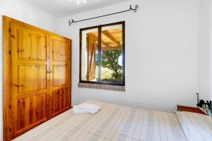 a bedroom with a bed and a window at Villa due Archi in S'archittu Cuglieri