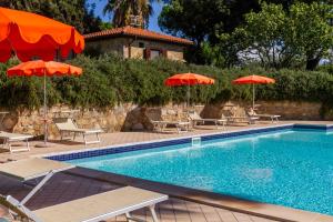 a swimming pool with chairs and umbrellas at Il Cancellone - Grillo in Montiano