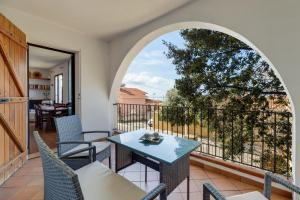 a room with a table and chairs on a balcony at Villa due Archi in S'archittu Cuglieri