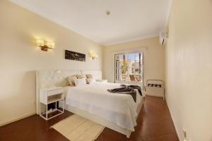a bedroom with a white bed and a window at Sol do Atlântico in Portimão +26 photos