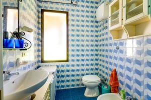 a blue and white bathroom with a toilet and a sink at Villa due Archi in S'archittu Cuglieri +13 photos