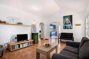 a living room with a couch and a tv at El Charco Azul in Charco del Palo