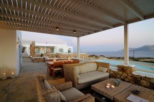 a patio with a table and chairs and a pool at Villa St' Astra in Koufonisia