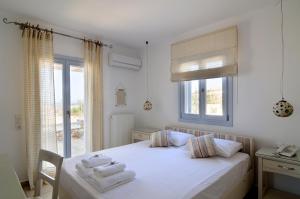 a bedroom with a bed with towels on it at Villa St' Astra in Koufonisia +37 photos