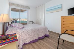 a bedroom with a bed and a view of the ocean at La Escala in L'Escala