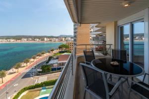 a balcony with a table and chairs and a view of the ocean at La Escala in L'Escala