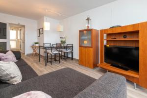 a living room with a large television and a table at La Escala in L'Escala