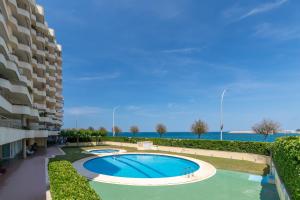 a swimming pool in front of a apartment building at La Escala in L'Escala