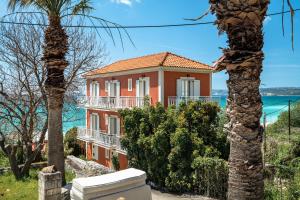 a house with a palm tree in front of it at Angela partial sea view 6 in Kefallonia